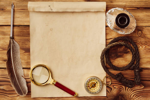istock Old paper on brown wood background with feather 1531105713