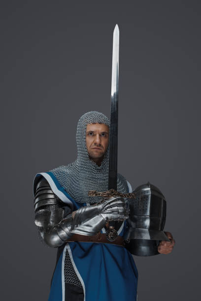 istock Proud knight stands holding his sword and helmet 1531144871