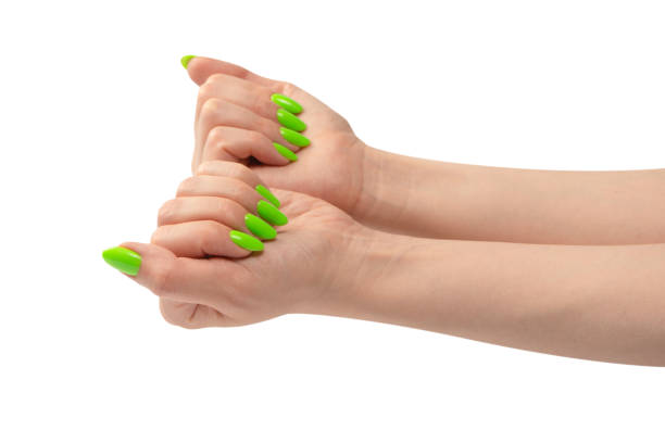 Hand of a woman with green naols hold some tiny or thin object.