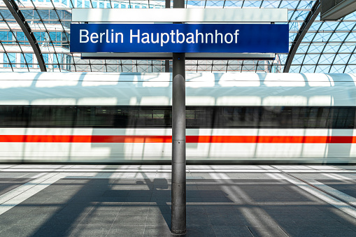 Station sign of Berlin Hauptbahnhof against leaving train, Berlin central