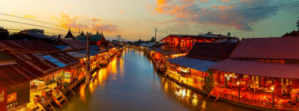 vue sur les villes du marché flottant d’amphawa et les touristes font du shopping, mangent et prennent des photos dans la région. il y a de nombreux restaurants dans la région. est l’un des - damnoen saduak floating market photos et images de collection