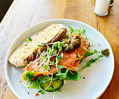 Smoked salmon open sandwich with salad and garnish, on sourdough bread