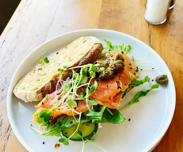 Open sandwich of smoked salmon, watercress, rocket, seeds, capers and more.