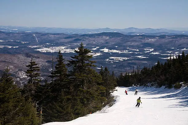Three people ski down from the summit of Sugarbush on a trail called Jester