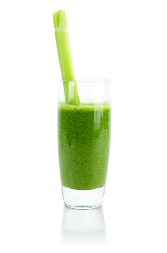 Wheat grass smoothie, with celery stick, isolated on white.