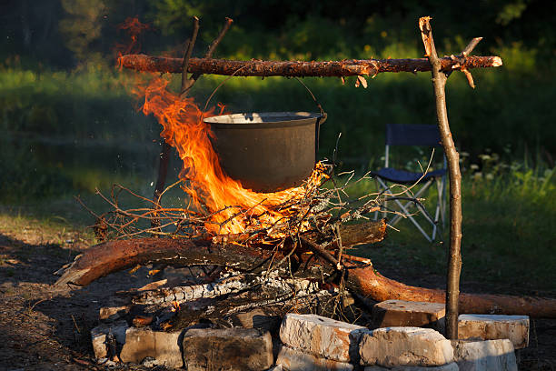 istock Preparing food in big pot on campfire 153124449