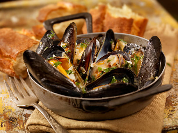 Sautéed Mussels Mussels in a Butter and White Wine Sauce with Garlic, Pepper and Fresh Parsley -Photographed on Hasselblad H3D2-39mb Camera mussel stock pictures, royalty-free photos & images