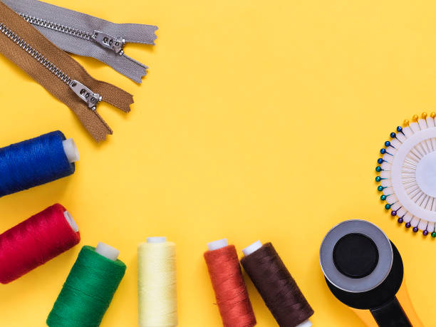 istock Roller cutter, colorful bobins, zippers on a yellow background. Sewing tools for tailoring. Flat lay. Copy space. 1531252538