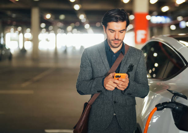 Businessman charging an electric car stock photo