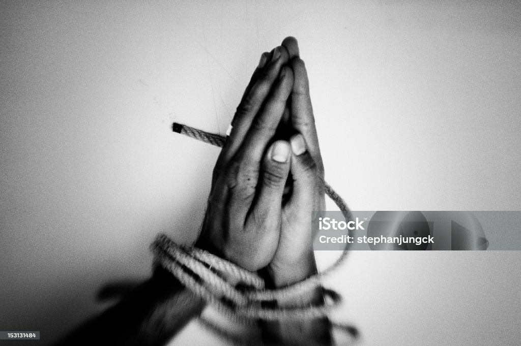 A black and white photo of hands bound together with rope Praying hands tied with a rope. Deliverence. Addiction Stock Photo