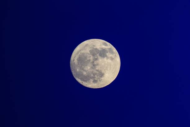 istock Full moon isolated in the blue backdrop of the sky. 1531320304