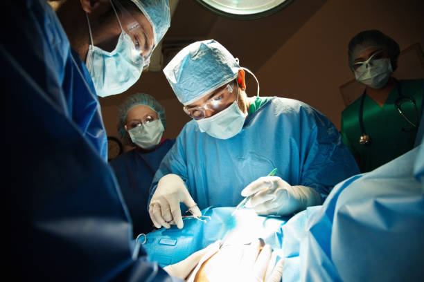 chirurdzy pracy c-section w sali operacyjnej. - cesarka zdjęcia i obrazy z banku zdjęć