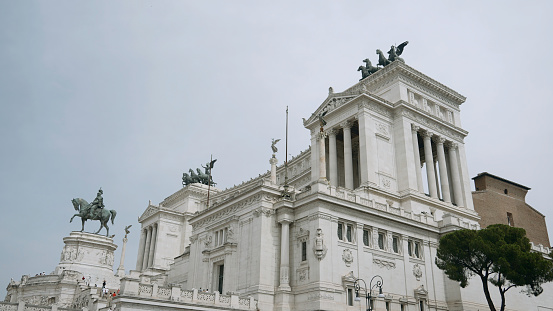 Italy, Milan - August 30, 2022: Famous buildings of Italy. Action. Beautiful monuments on architectural palace of Italy. Cultural attractions and sculptures on buildings of ancient historical city. Monuments and Vittoriano Palace in Rome.