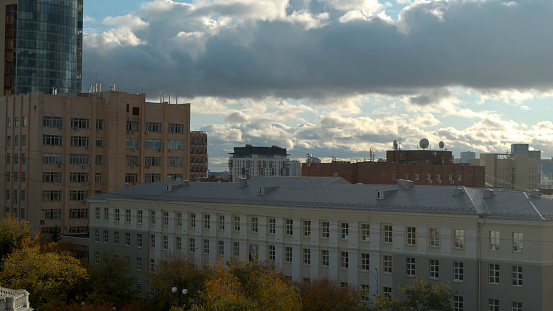 Serbia, Belgrade - May 7, 2022: Flying above houses and buildings on a blue cloudy sky background. Stock footage. Residential buildings in the city center