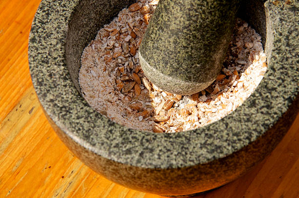 Corn being grinded with mortar and pestle stock photo