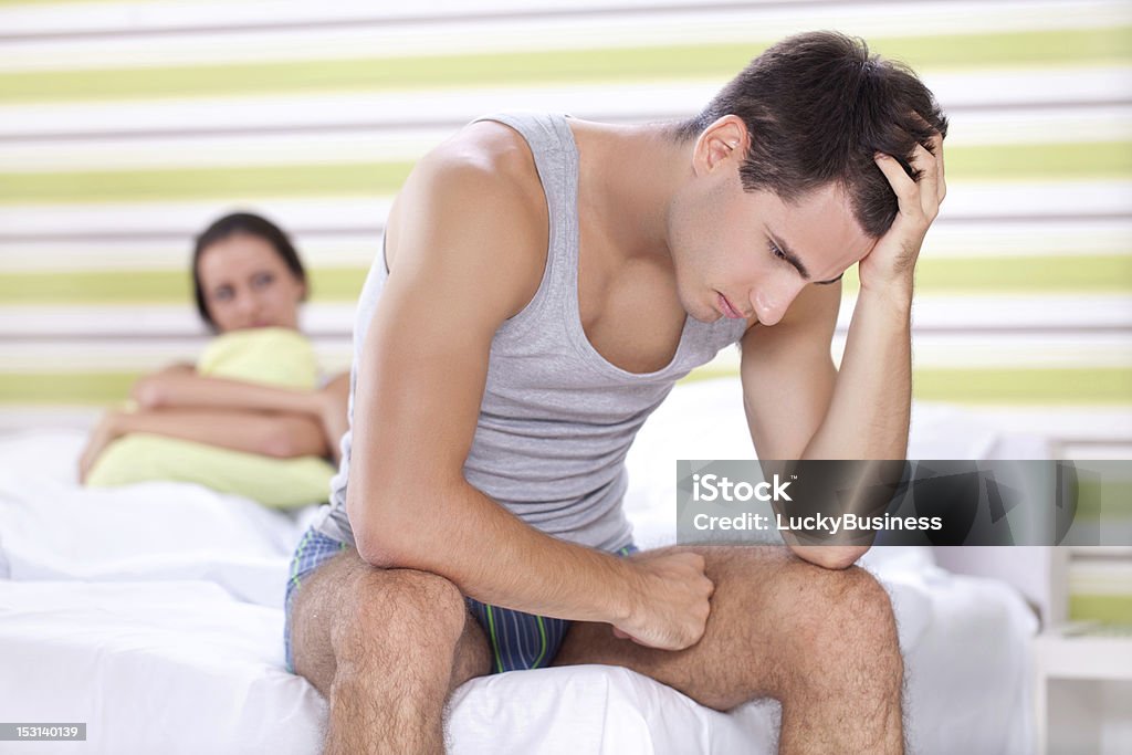 Unhappy couple in bedroom Unhappy young couple with problem  in bedroom Erectile Dysfunction Stock Photo