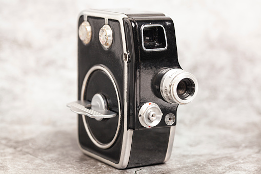 An old medium format camera with bellows lens from the 1940-50s on white background close up.