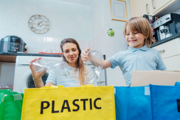 istock Mother is teaching kid how to recycle help the boy aware environmental importance - mom educates son sort garbage into different bins on kitchen. Family sorting garbage at home. Concept of recycling. 1531437703