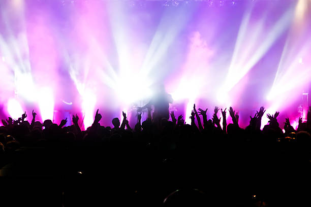 istock Concert crowd in front of purple spotlights 153146457