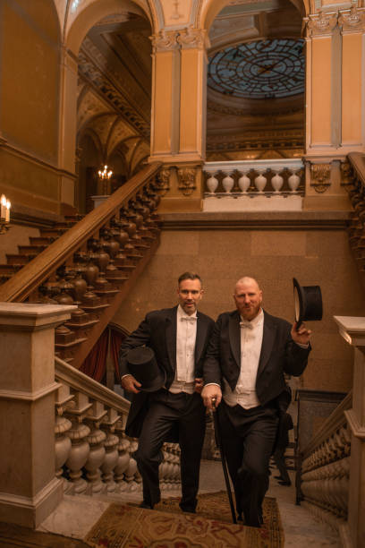 istock Two handsome 1920s style gentlemen on a luxury stately home staircase 1531475670