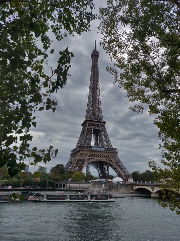 Eiffel Tower in France framed by trees along the river