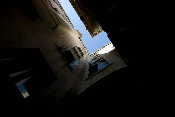 A photo of buildings in Venice taken towards the sky from a small enclosed courtyard at ground level