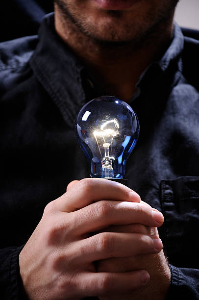 istock young man with light bulb in his hands 153150506