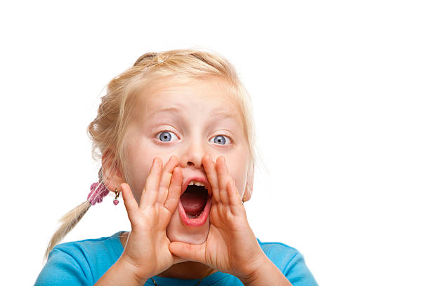 Young cute blond girl screams loud into camera stock photo