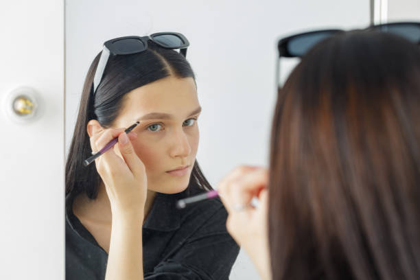 istock girl doing her makeup at home in front of a mirror 1531513709