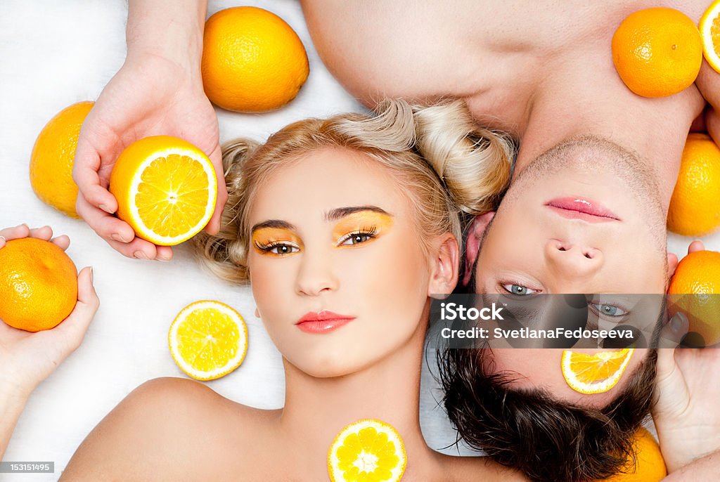 Jeune couple avec des oranges - Photo de Hommes libre de droits