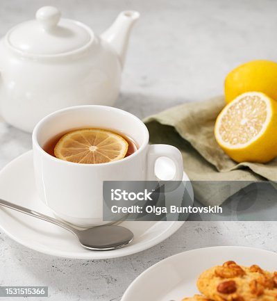istock A  cup of tea with lemon and homemade cookies on a light background with a white teapot and citrus close up. 1531515366