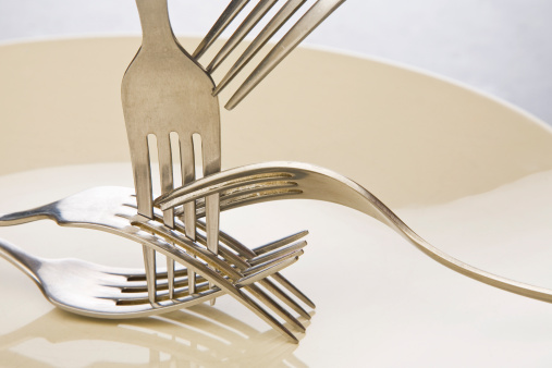 Arrange empty of forks on a plate in warm light