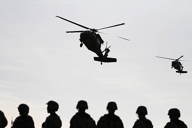 Soldiers Await Blackhawk Pickup United States Army soldiers are awaiting the blackhawks to pick them up. military deployment photos stock pictures, royalty-free photos & images