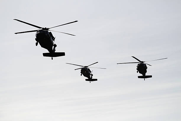 Three Blackhawks Approaching Three Blackhawks are inbound to pickup soldiers. military deployment photos stock pictures, royalty-free photos & images