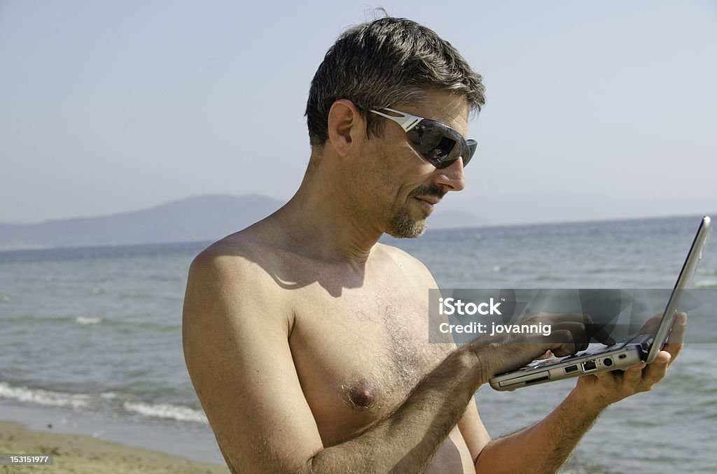 Man relaxing on the Beach with his Notebook Man relaxing on the Beach with his Notebook, Italy Adult Stock Photo