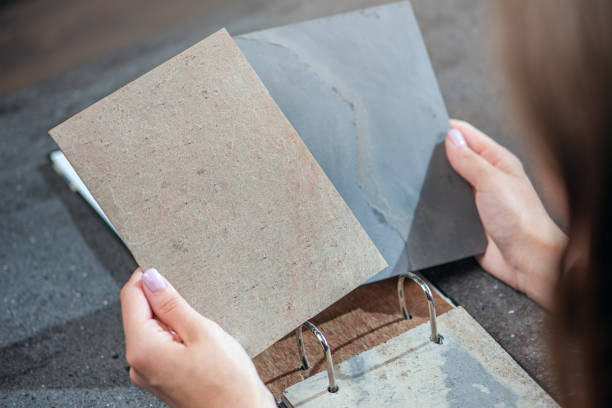 istock Samples of artificial stone in hands close-up. Natural stone veneers for finishing interior elements and furniture. 1531521068