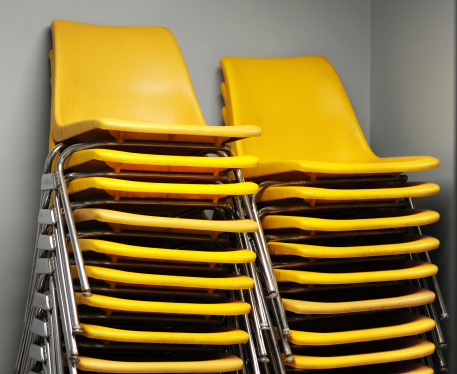 Shot of two columns of stackable yellow chairs.