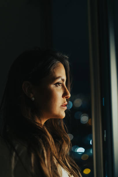 istock Beautiful young woman looking through the window 1531548357