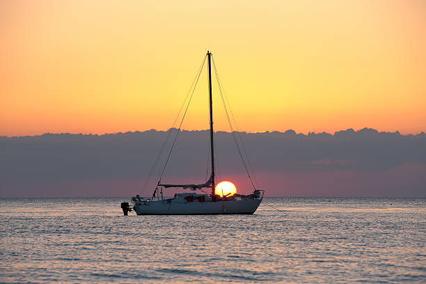 Sunset with boat Sunset with sailing boat at Napes Florida Beach. naples beach stock pictures, royalty-free photos & images