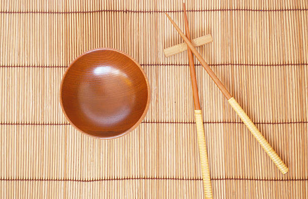 istock Chopsticks with wooden bowl on bamboo matting background 153155530