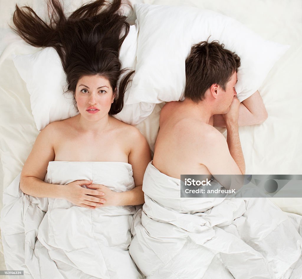 Man and woman in bed not getting along a couple lying in bed Adult Stock Photo