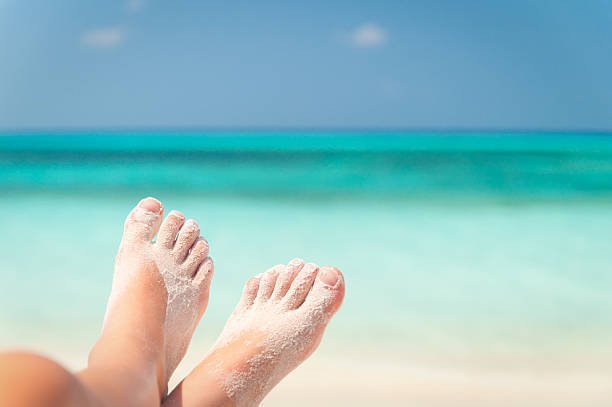 istock Macro of sandy feet on beach with blurred sea on background 153159471