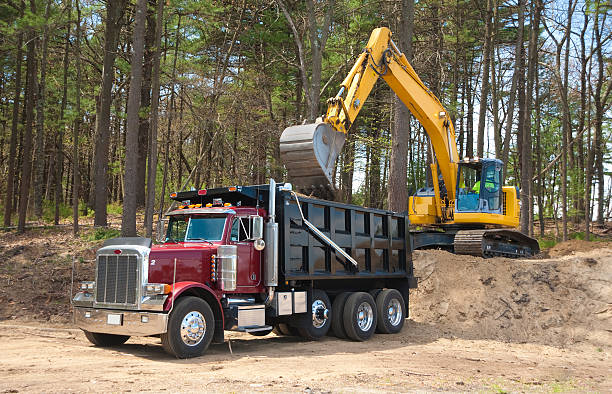 Excavator loading dumper truck stock photo