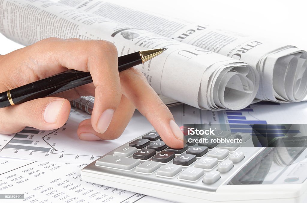 womans hands using calculator and a pen womans hands using calculator and a pen on her finger. newspaper on a background Adult Stock Photo