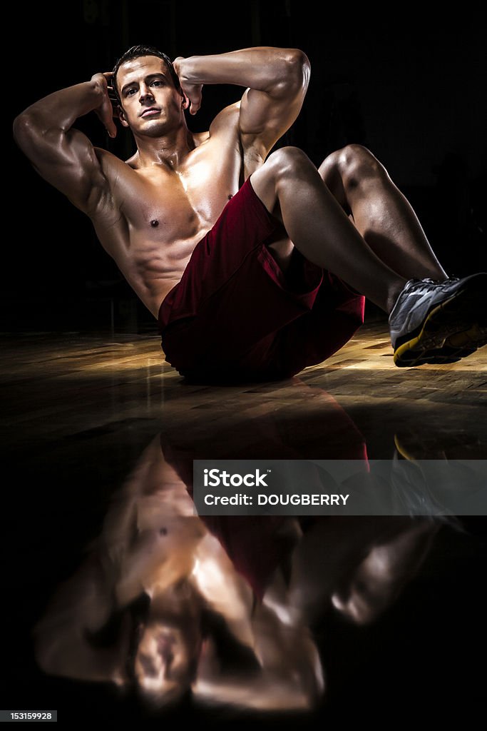 Sit ups Man doing sit ups on gym floor Exercising Stock Photo