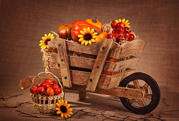 Wooden wheelbarrow decoration with sunflowers and and pumpkins