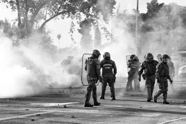 soziale demonstration in santiago, chile - bereitschaftspolizist stock-fotos und bilder