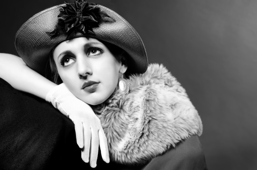 Retro styled fashion portrait of a young woman in hat. Clothing and make-up in vintage 1920s style