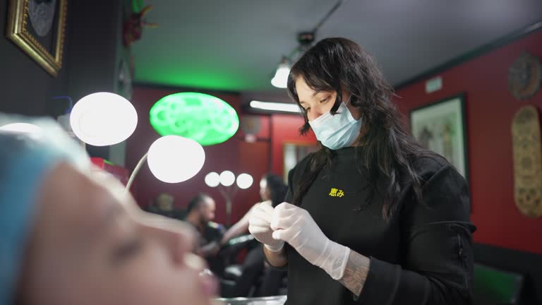 Woman doing piercing at tattoo studio