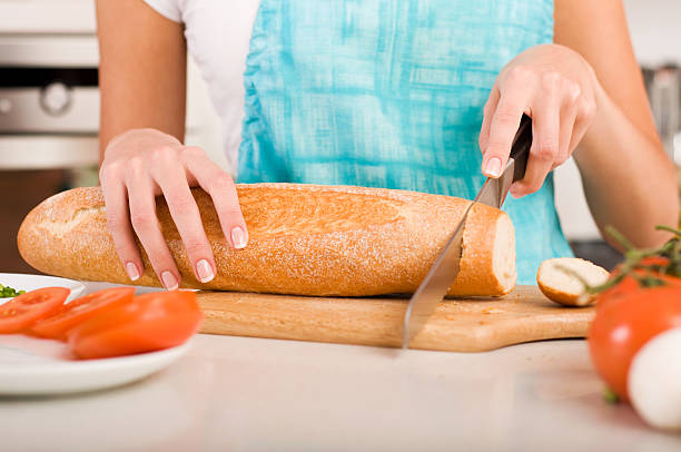 istock Woman cutting bread on the kitchen (shallow DOF) 153163408